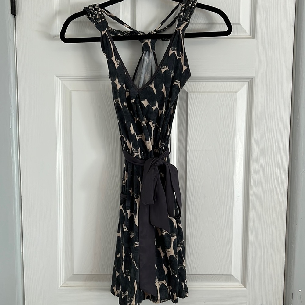 Short dress. Adjustable straps. Pockets. Ribbon tied around waist.